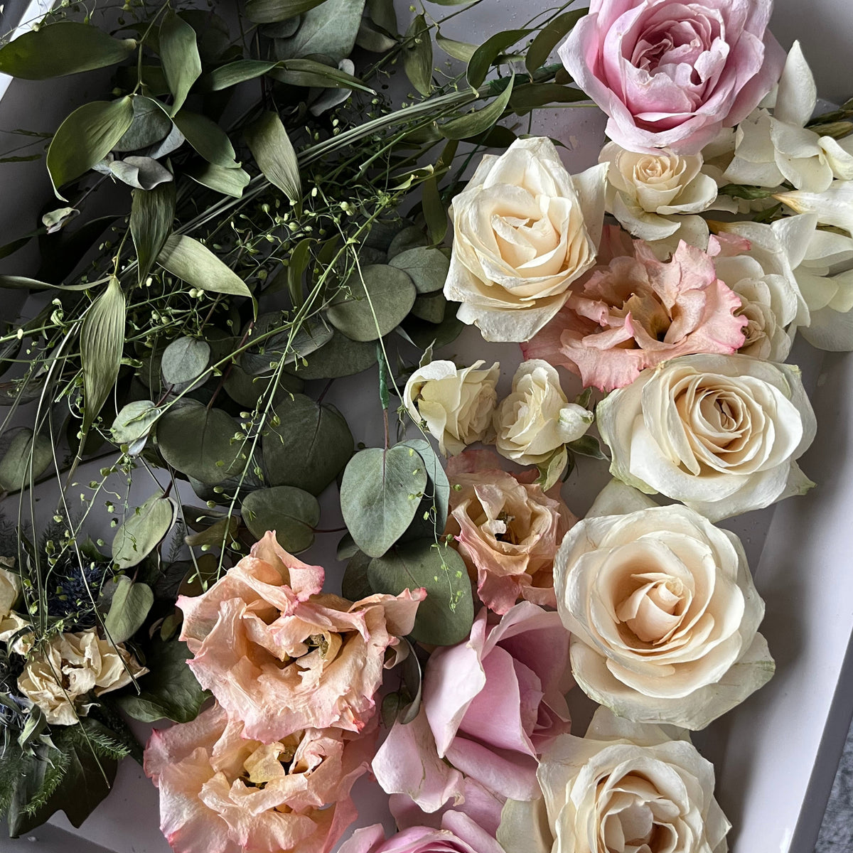 Bouquet of pink, white, and green flowers on a grey surface